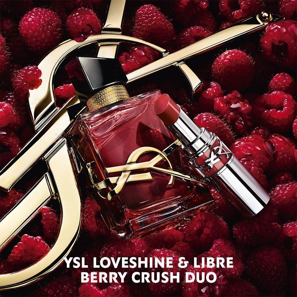Libre Eau de parfum Berry Crush and Loveshine lipstick in Berry Crush, with the Cassandre logo, on a bed of raspberries.