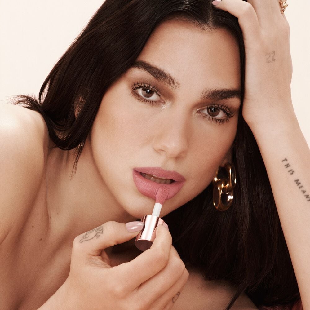 Iconic portrait of Dua Lipa holding YSL LOVENUDE LIP STAIN, highlighting the second-skin nude lip look.