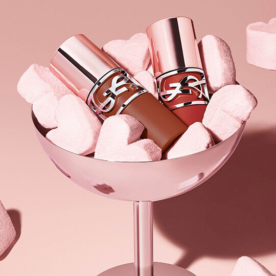 YSL Lash Clash mascara on a reflective surface, showcasing the bold black texture and couture packaging.