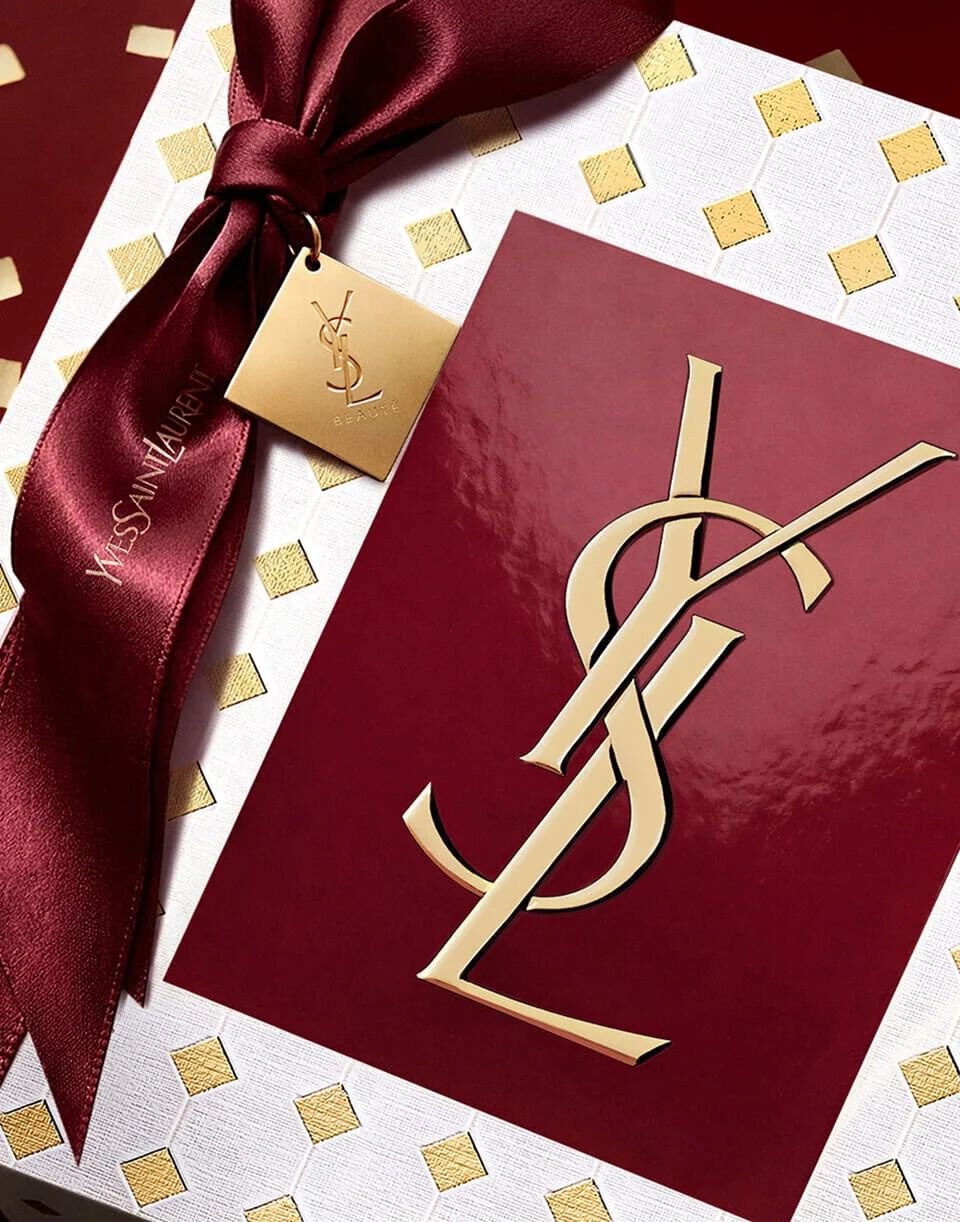 Couture burgundy YSL Holiday gift box tied with a luxurious ribbon and embossed gold logo.