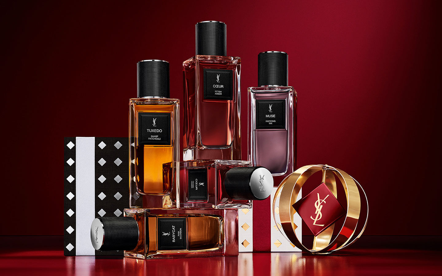 YSL Le Vestiaire des Parfums luxury bottles set on patterned Holiday gift boxes.