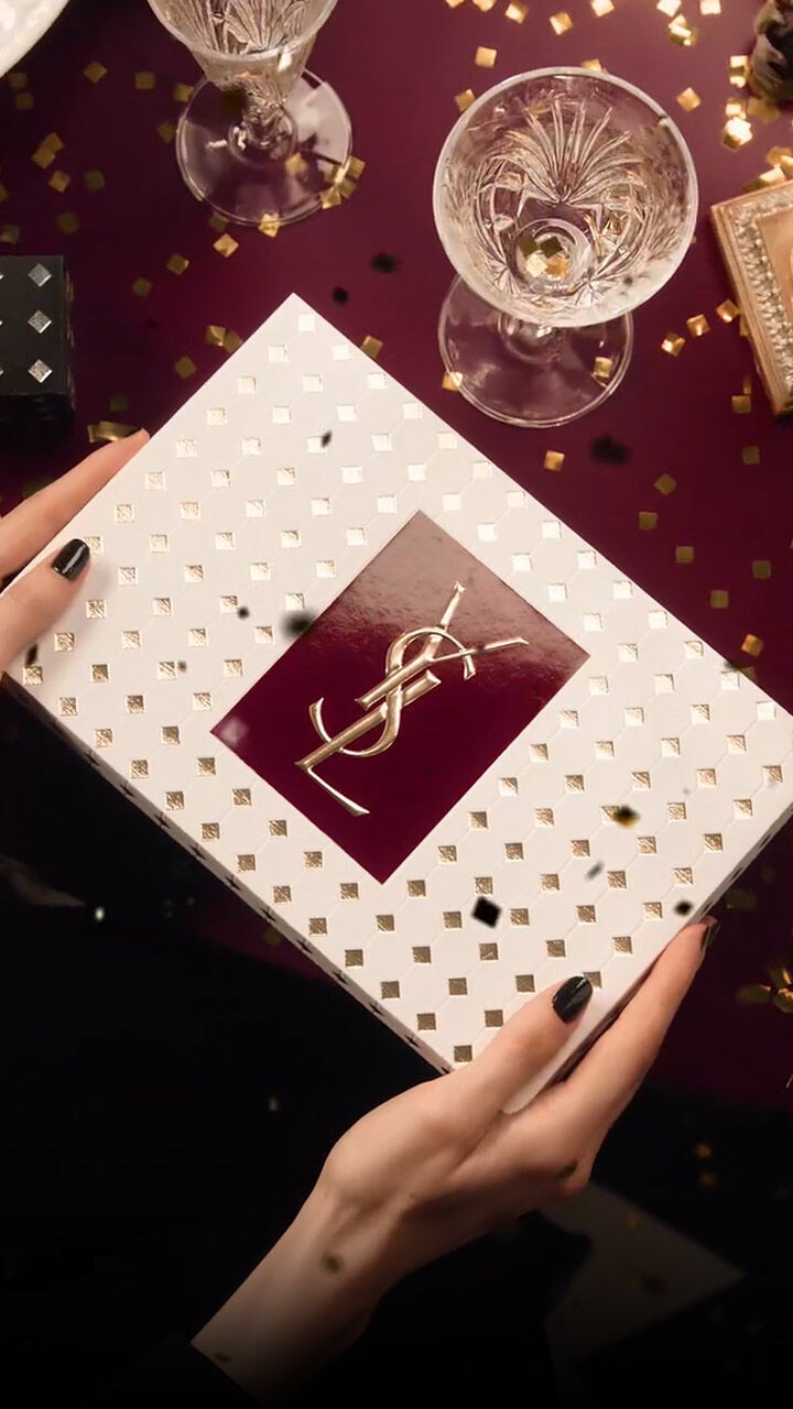 Video of guests at a festive YSL dinner, sharing joy and gifting luxury holiday sets in a decadent atmosphere.
