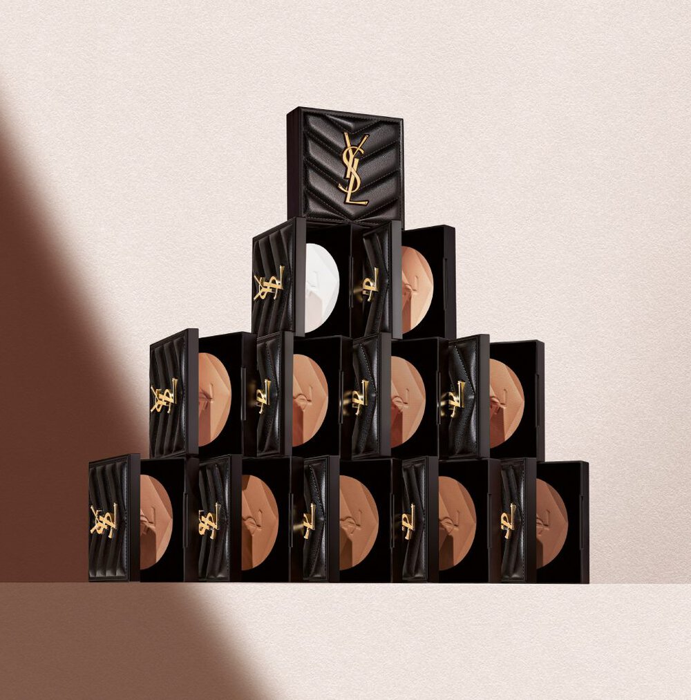 YSL Beauty All Hours Hyper Finish Powder stacked in a pyramid, showcasing various shades in luxurious black and gold packaging