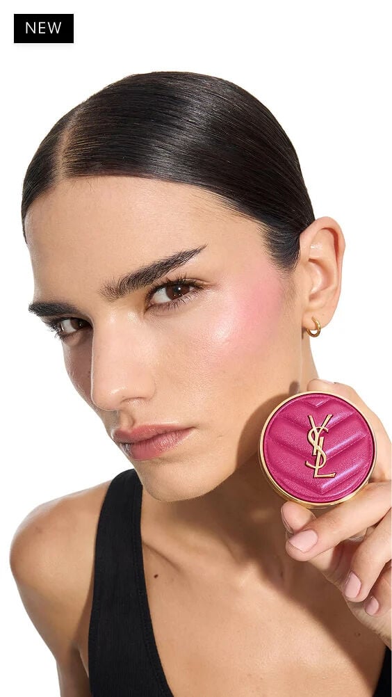 Iman, medium skin, holding a fuchsia YSL Make Me Blush Powder Blush in shade 66, showcasing vibrant blush on her cheek.