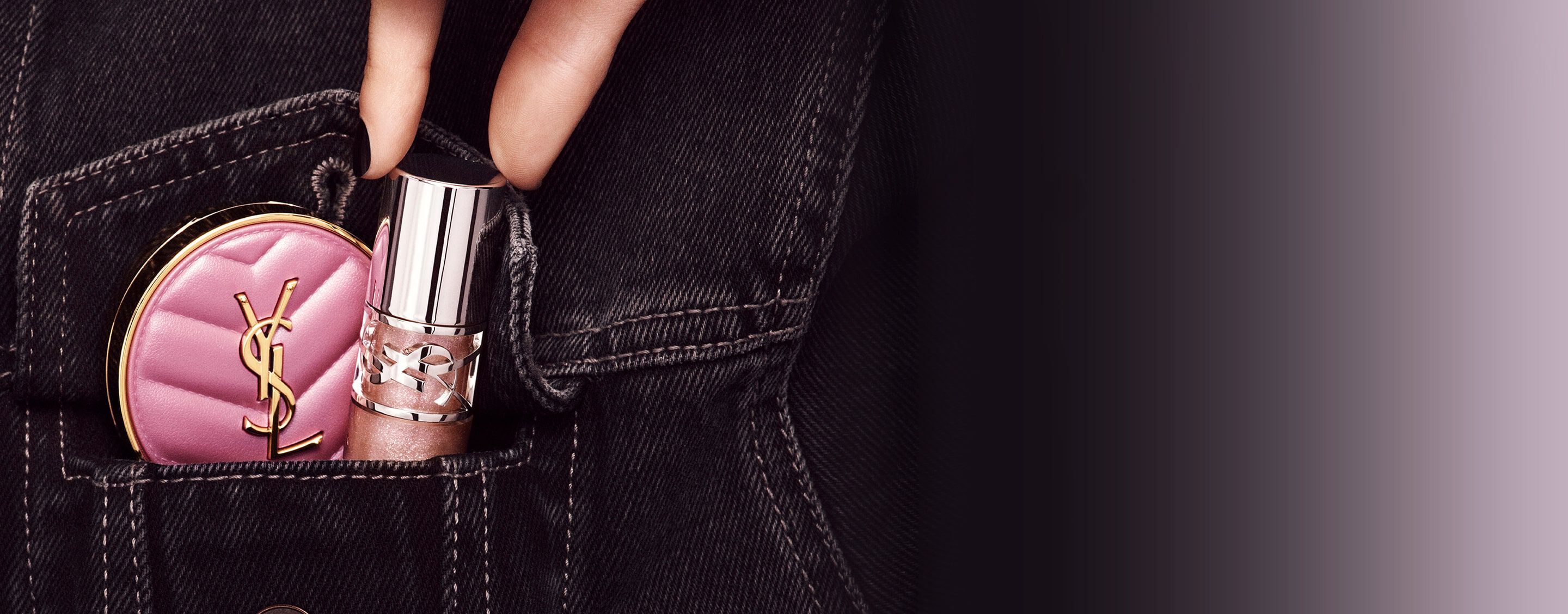 Hand placing YSL LOVESHINE Lip Oil Gloss and pink Make Me Blush compact into a denim pocket