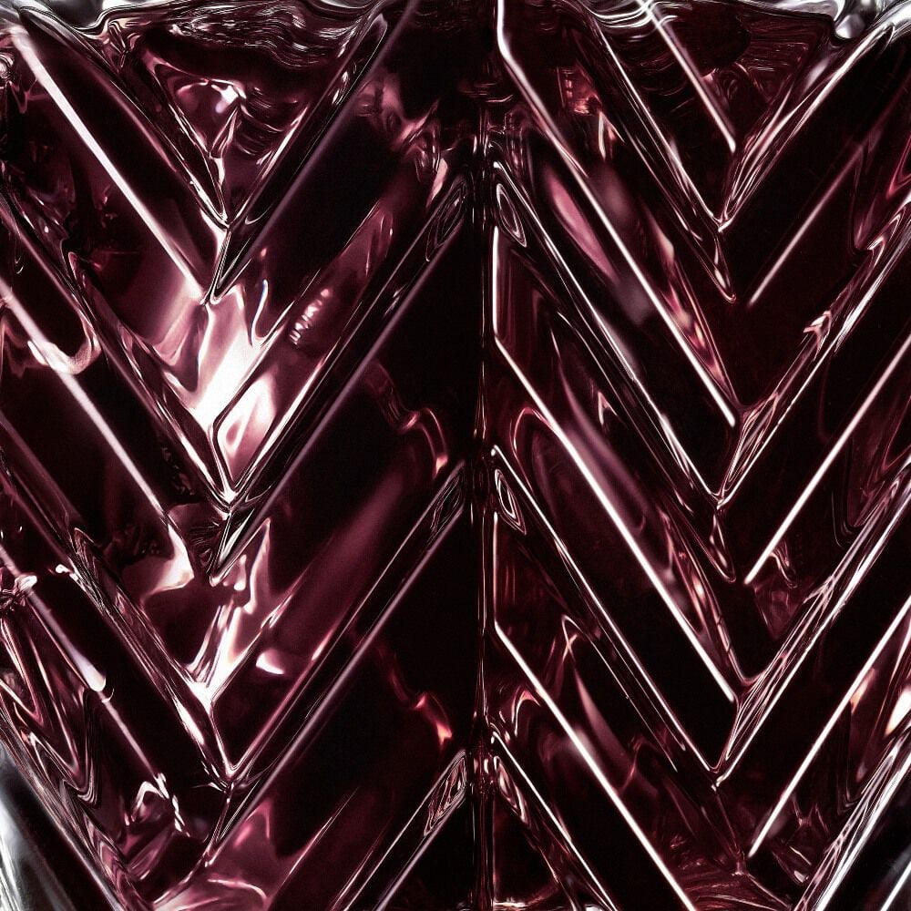 YSL LVDP Muse Extrait de Parfum 50ml bottle, close-up of deep red glass chevron texture
