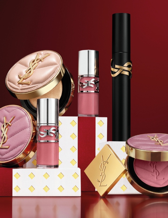 Multiple YSL LIBRE fragrance bottles layered over luxury gold-patterned Holiday gift packaging.