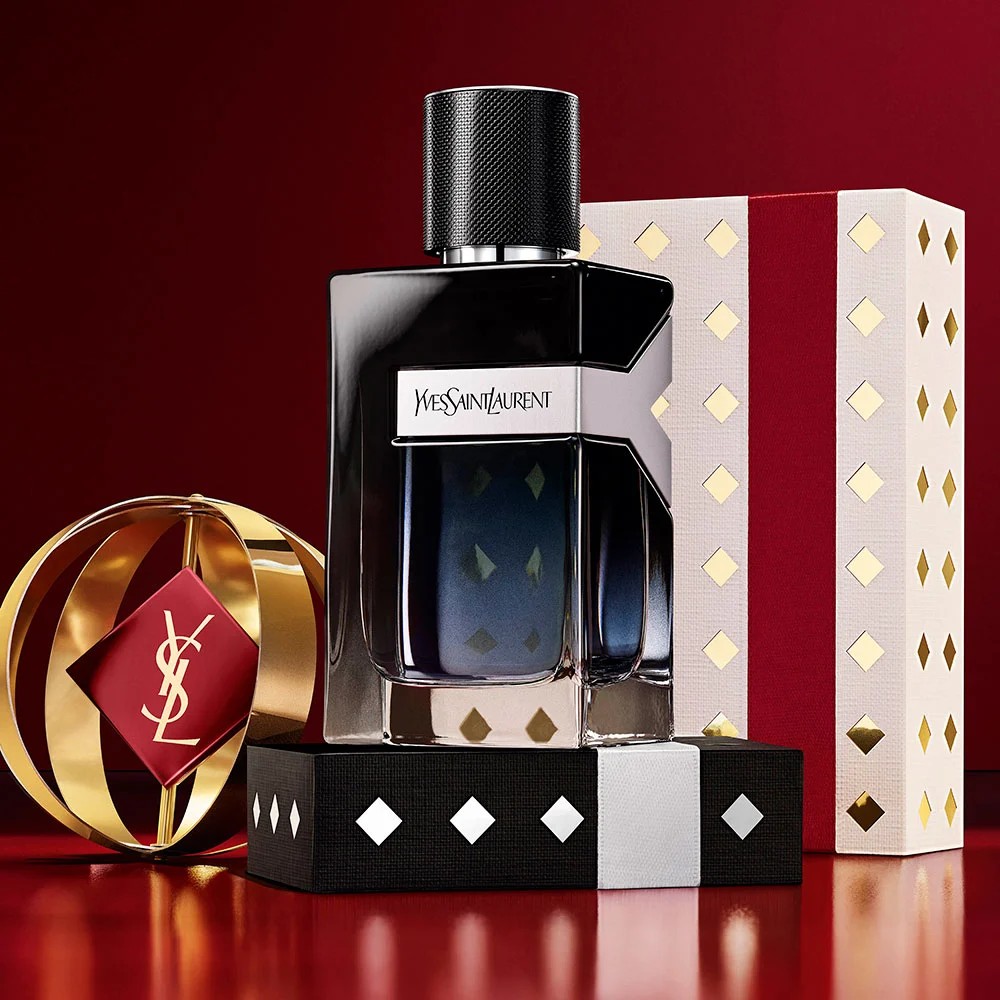 Multiple YSL LIBRE fragrance bottles layered over luxury gold-patterned Holiday gift packaging.